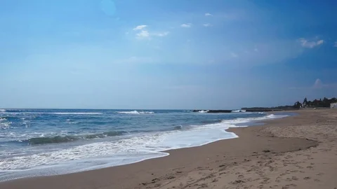Deserted beach stretching away with foamy ocean waves coming to the dark sand Stock Footage 82806485