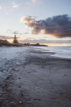 Deserted beach at sunset with dramatic clouds in the sky Foto stock