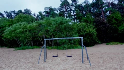 Deserted beach swing set on sand dunes against lush pine trees in Jurmala Stock Footage 344355936