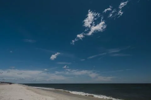 Deserted empty sandy beach in sunshine, blue skies and clouds in Fire Island New Stock Photos