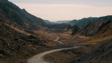 Deserted road winds through mountains in serene natural landscape Stock Footage 321430181