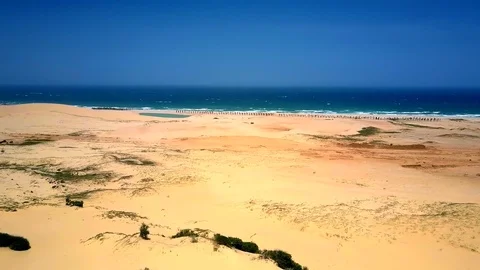 Deserted sandy ocean beach under clear blue sky Stock Footage 100342629