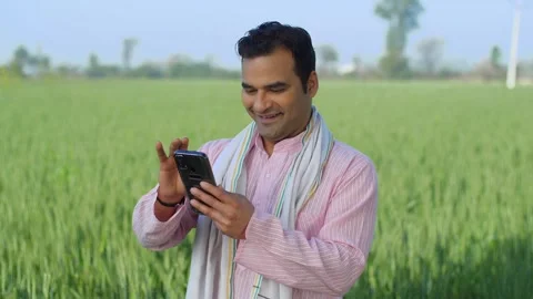 Desi young Indian farmer using smartphone on field - modern agriculture, tech... Video stock 270026097