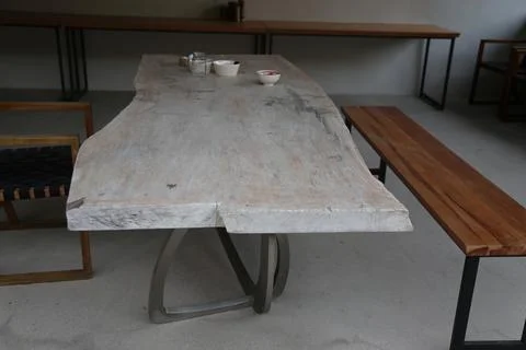 A design cafe table with a white-washed wood top, metal legs, and a bench. .. Stock Photos