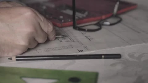 Design Engineer Checking Blueprint Measurements with Precision Drawing Compass Stock Footage 341926943