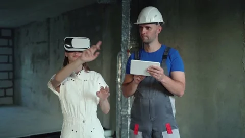 Design engineer shows a construction project to a woman wearing virtual reality Stock Footage 254769702