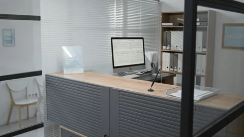 Design of Reception Desk with Desktop Computer and Bookcase at Modern Hospital Stock Footage 332664193