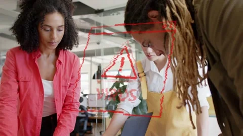Design team arranging mockups, red VIRUS warning appearing over laptop, Stock Footage 333789819