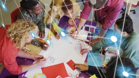 Design team leaning over round table spreading swatches, forming overlay linking Stock Footage 333192945