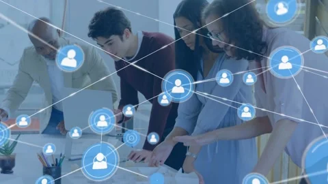 Design team leaning at table while man using laptop starting blue nodes web Stock Footage 329812865