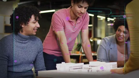 Design team reviewing scale model, seated man tapping model causing AR nodes 库存影片 333998862