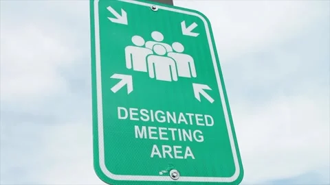 Designated meeting area vertical rectangle green and white sign on post with sky Stock Footage 249752683