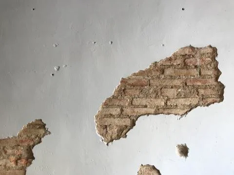 Designed antique white cement wall with cracked space which shows old brick Stock Photos