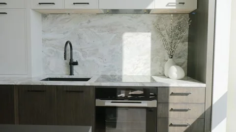 Designed in neutral colours kitchen with black sink tap, electric oven and lots Stock Footage 265173350