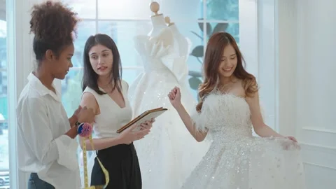Designer and assistance using laptop to design wedding dress for beautiful bride Stock-Footage 232570044