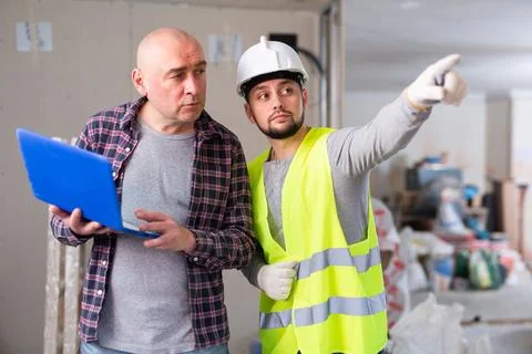 Designer and foreman talking about work in construction site Stock Photos