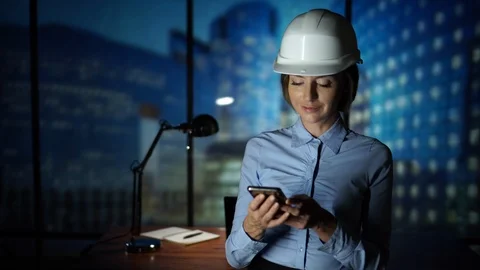 Designer Architect in the Hardhat using smartphone, texting, new technology Stock Footage 95558346