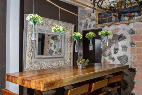 Designer bar stools at gray kitchen island with bottles under grey lamp in br Stock Photos
