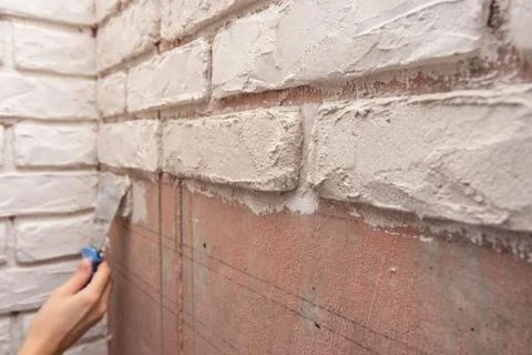 Designer bricks with a spatula on the wall Stock Photos