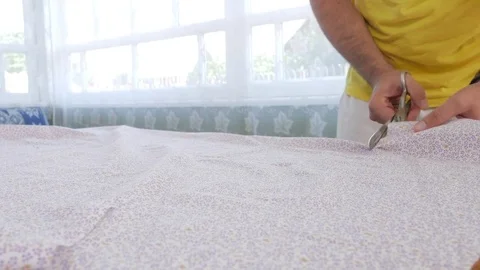 A designer clothes designer notes and cuts fabric details with scissors. Very Stock Footage 78620950