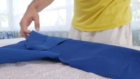 A designer clothes designer notes and cuts fabric details with scissors. Very Stock Footage 78621098