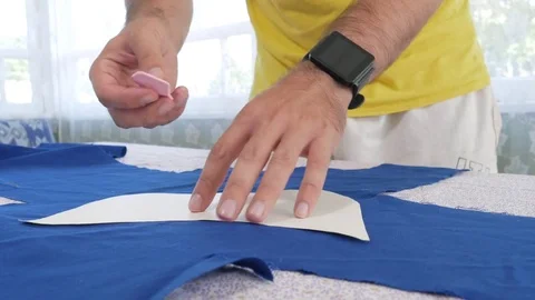 A designer clothes designer notes and cuts fabric details with scissors. Very Stock Footage 78621249