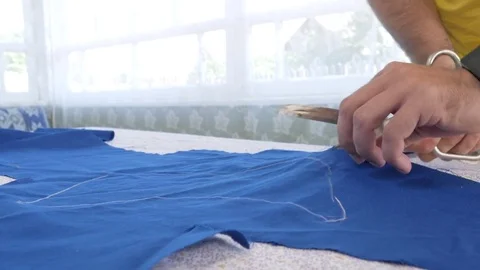 A designer clothes designer notes and cuts fabric details with scissors. Very Stock Footage 78621437