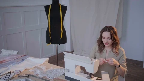 Designer clothes preparing sewing machine for operation Stock Footage 126859597