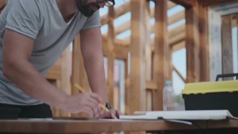Designer in a construction helmet on the background of scaffolding Stock-Footage 138193392