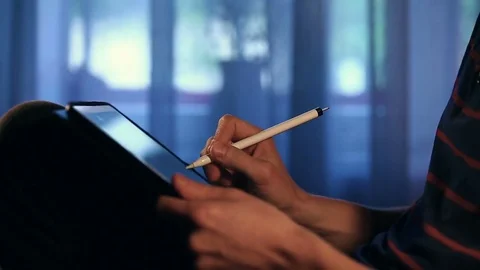 Designer create a sketch on his tablet using a stylus at home. Video stock 82361326