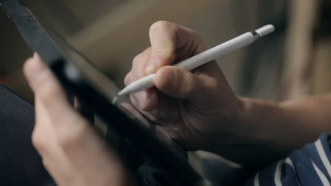 Designer create a sketch on his tablet using a stylus at home Vidéo 94974173
