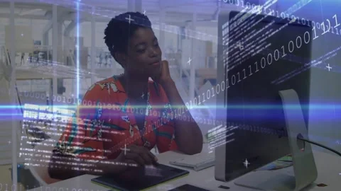 Designer at desk pen hovering on tablet starting binary code and light streaks Stock Footage 333901488