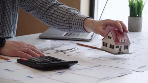 The designer develops the project at the table with a laptop and drawings 스톡 동영상 323158098