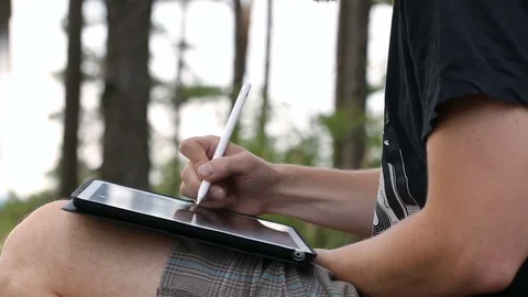 Designer Drawing and scaling On Tablet using stylus on nature Video stock 80525033
