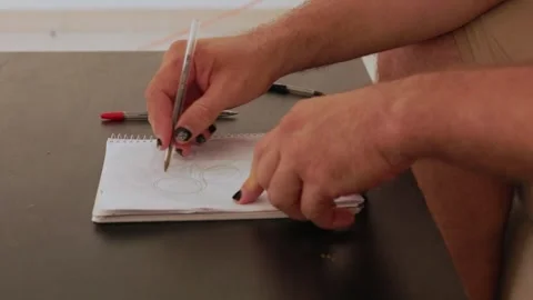 Designer drawing circles with pen on notepad Stock Footage 316128171