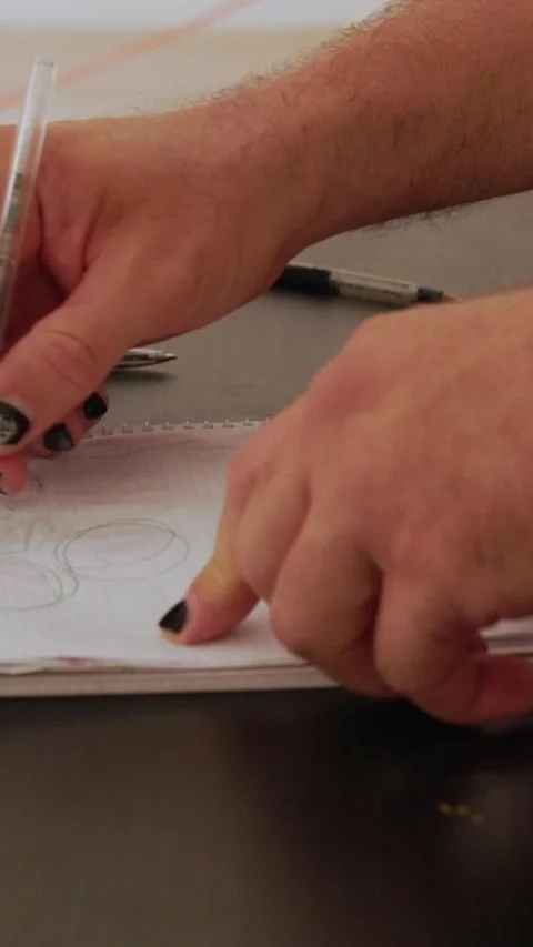 Designer drawing circles with pen on notepad Stock Footage 327862468