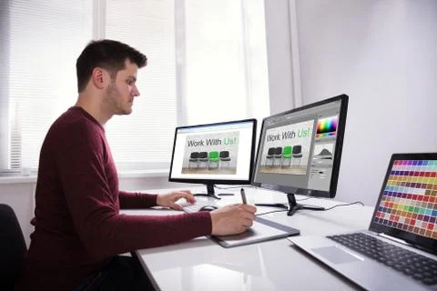 Designer Drawing On Graphic Tablet While Working On Computer Stock Photos