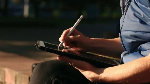 Designer Drawing sketch On Tablet using stylus at park Video stock 82359843