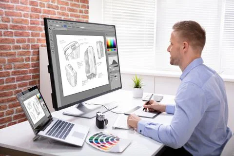 Designer Drawing Suitcase On Computer Using Graphic Tablet Stock Photos