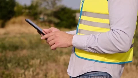 A designer inspects a high voltage tower. An engineer in a hard hat servicing a Vidéo 252667322