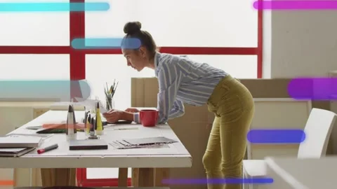 Designer leaning over laptop, typing and causing neon bars sliding across frame Stock Footage 333936613