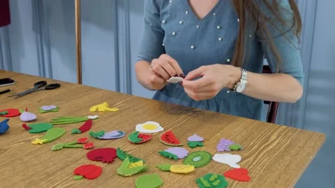 Designer makes, sews soft childrens toys from fabric. In the form of fruits  Stock Footage 131065683