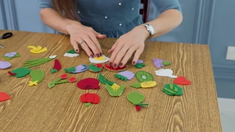 Designer makes, sews soft childrens toys from fabric. In the form of fruits Stock Footage 131066725