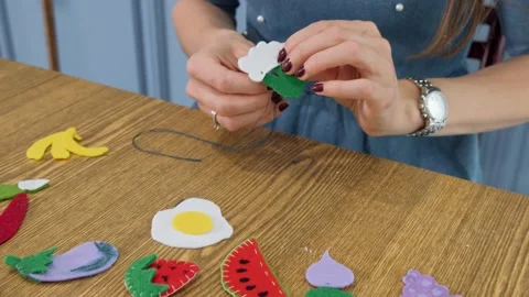 Designer makes, sews soft childrens toys from fabric. In the form of fruits Stock Footage 131066766