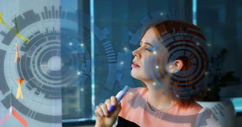 Designer reaching clear panel, drawing with blue pen and inspecting marks with Stock Footage 321824880