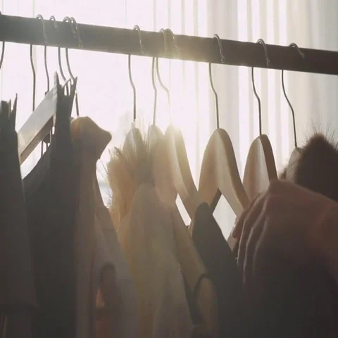 Designer with a ready collection. Sunlight between hangers Stock Footage 69547326