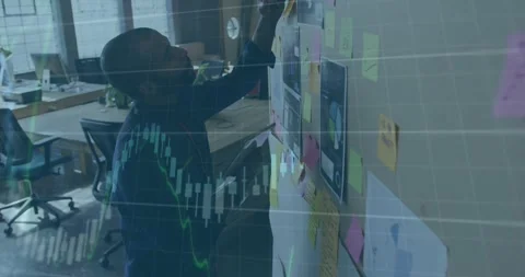 Designer scanning board, arranging notes while candlestick overlays animating, Stock Footage 332275601
