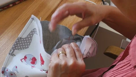 Designer sewing button onto hand made bag Stock Footage 77112849