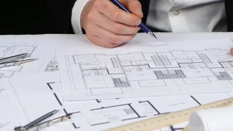 Designer sits at the table, chooses a drawing that is more optimal for him Stock Footage 73679619