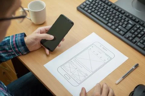 Designer sketches the layout of a responsive website or app and tests it on a Stock Photos